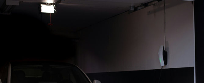 A garage with an electric vehicle parked inside, where the misuse of lithium ion batteries can easily lead to a fire.